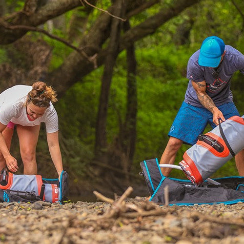 two people setting up paddleboards