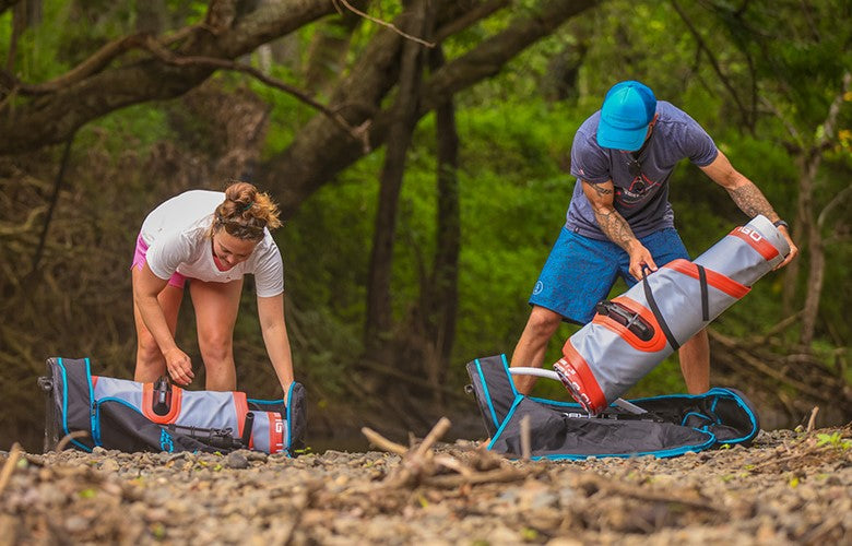 two people setting up paddleboards