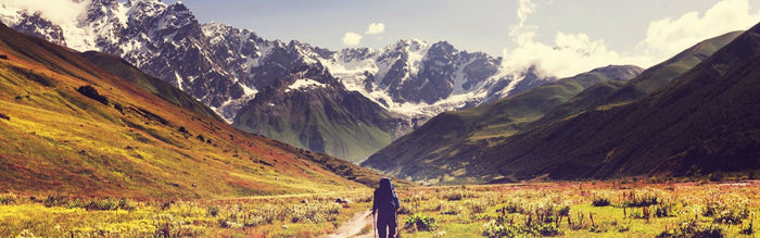 a person backpacking walking towards mountains